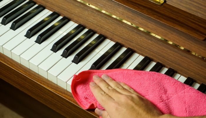Cleaning piano keys with a rag
