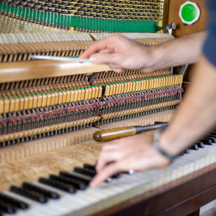 Piano tuner working inside a piano