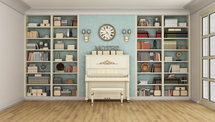 White piano in room with books