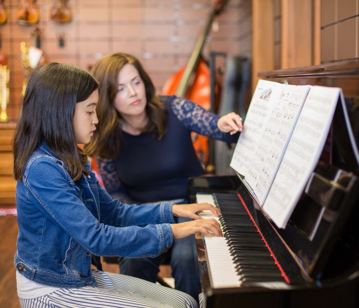 Woman teaching piano to a child